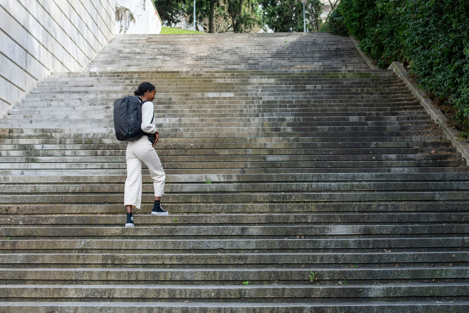 Woman walking on stairs wearing backpack